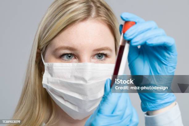 Young Blonde Nurse With Medical Glove Is Handling A Blood Probe Stock Photo - Download Image Now