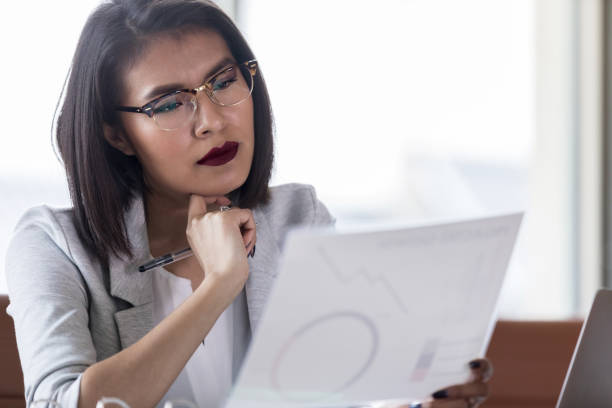 istock Businesswoman concentrates while examining a chart 1138904467