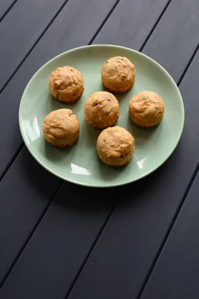 Diet and healthy dessert concept. Sugar free muffins in green plate on dark background minimalist style top view copyspace