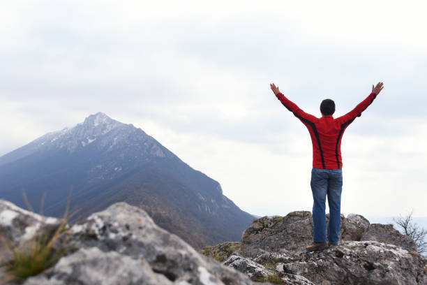 istock Man rise a hands on top of the mountain 1138912581