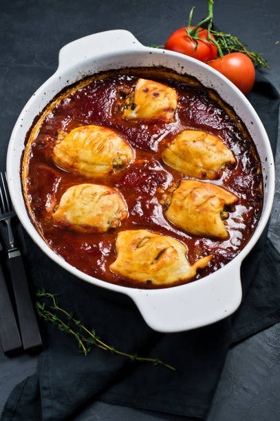 istock Dish with stuffed baked squid in tomato sauce. Black background, top view, space for text 1138913293