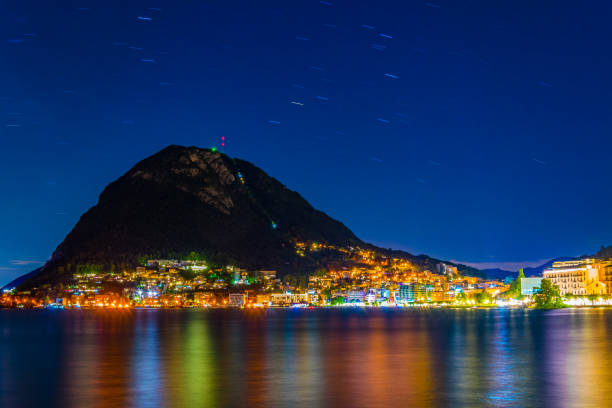 スイスのサン・サルヴァトーレ山の下にあるルガノの夕日 - lugano ストックフォトと画像