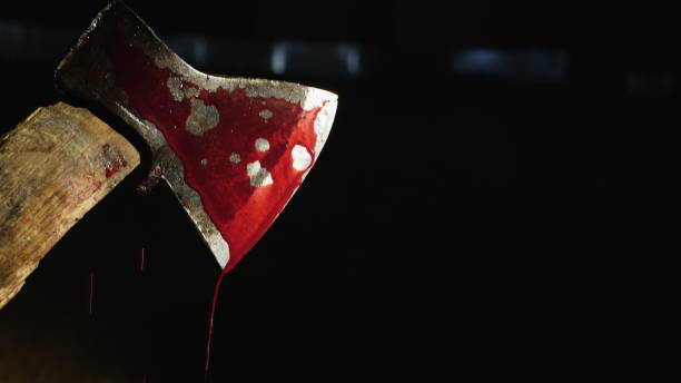 Axe with blood in hand on the dark background Closeup video: Axe with blood in hand on the dark background. Drops of blood flow down the blade of an ax. Murderer or butcher, halloween theme axe photos stock pictures, royalty-free photos & images