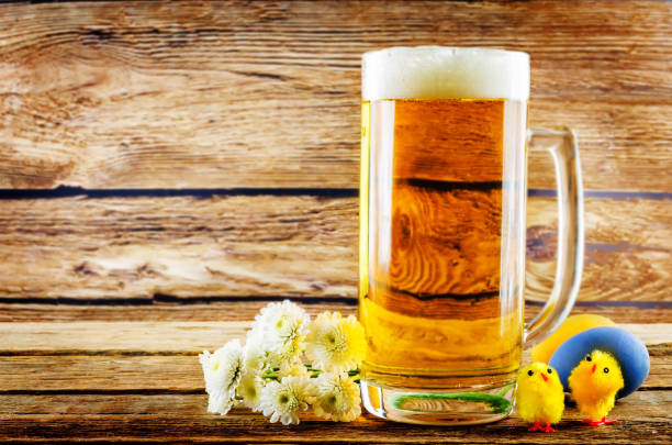 Glass of cold light beer with Easter decorations on a wood background for the Easter holidays. toning. selective focus