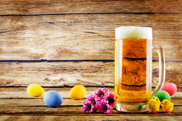 Glass of cold light beer with Easter decorations on a wood background for the Easter holidays stock photo