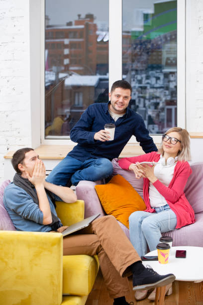 istock Friends sit on the couch, chatting and using a smartphone, desktop computer, laptop. 1138917885