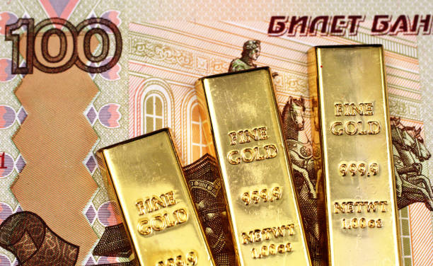 One hundred Russian ruble bill with three gold ingots stock photo