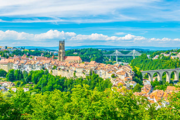 Tower of the cathedral of Saint Nicholas standing over skyline of Fribourg, Switzerland Tower of the cathedral of Saint Nicholas standing over skyline of Fribourg, Switzerland fribourg city switzerland stock pictures, royalty-free photos & images