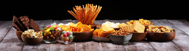 istock Salty snacks. Pretzels, chips, crackers in wooden bowls on table 1138932151