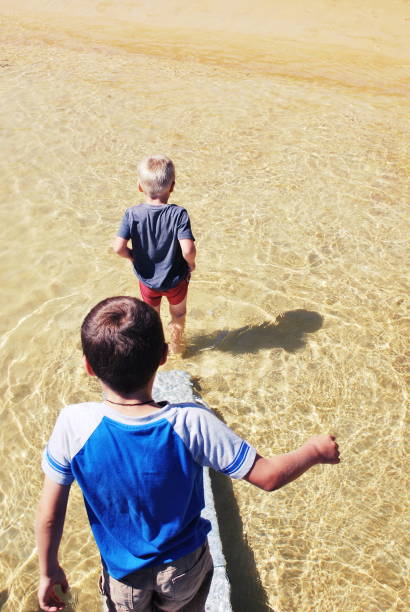 istock Children walk down Boat Ramp into Sea 1138933434