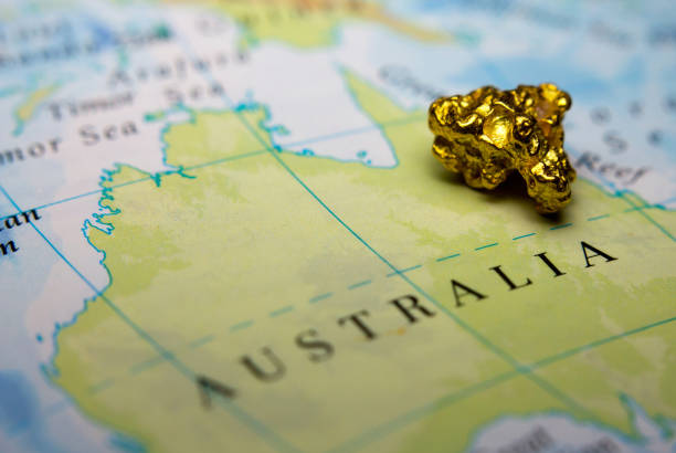 goldnugget auf der karte von australien - gold edelmetall stock-fotos und bilder