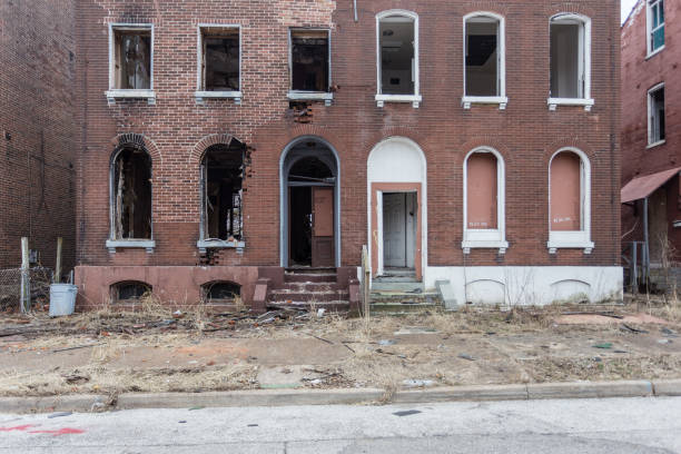 istock Matching abandoned red brick apartment buildings with grass growing through concrete 1138944749