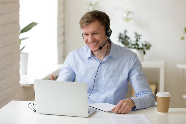 homme de sourire dans le casque faisant l’appel vidéo d’affaires - zoom victory photos et images de collection