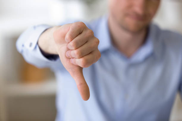 Dissatisfied business man showing thumbs down at workplace Close up of unrecognizable businessman with dissatisfied face showing negative sign, dislike with thumbs down, rejection concept at workplace, sign no, not approved, unhappy customer disappointment stock pictures, royalty-free photos & images