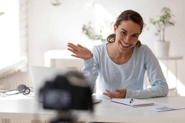 istock Smiling beautiful woman waving her hand looking at camera 1138947356