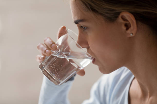 perfil de primer plano retrato de mujer bebiendo agua pura de vidrio - sediento fotografías e imágenes de stock