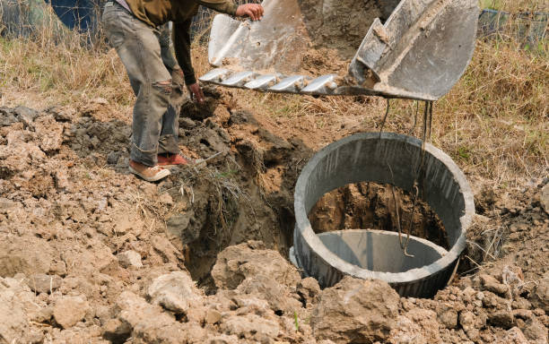 istock excavator backhoe burying pipe on ground at construction site 1138947667