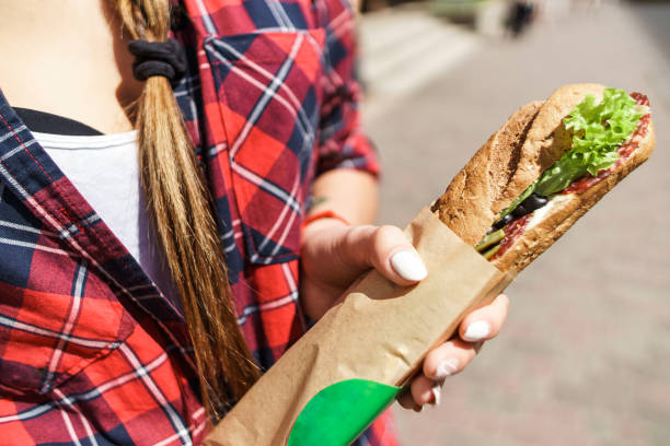 istock female hand holding a sandwich 1138947745