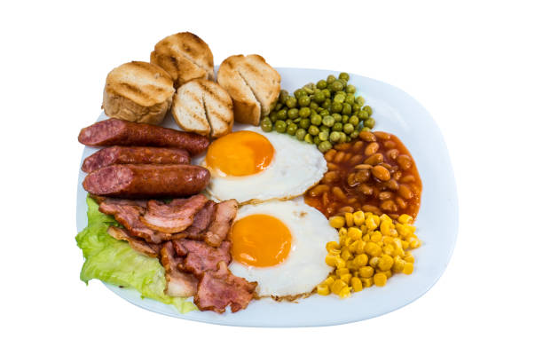 istock breakfast fried egg peas, corn grains, beans fried sausages and fried bacon on a white plate isolated 1138947761