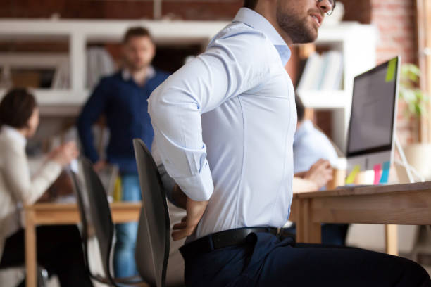 istock Businessman suffers from lower back pain sitting in shared office 1138949154