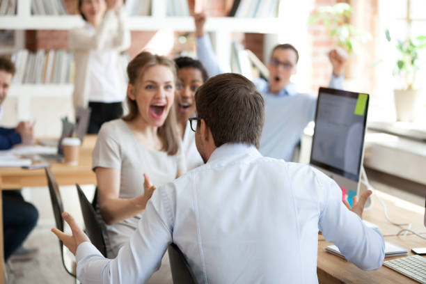 istock Diverse business people celebrating victory sitting in shared office 1138949170