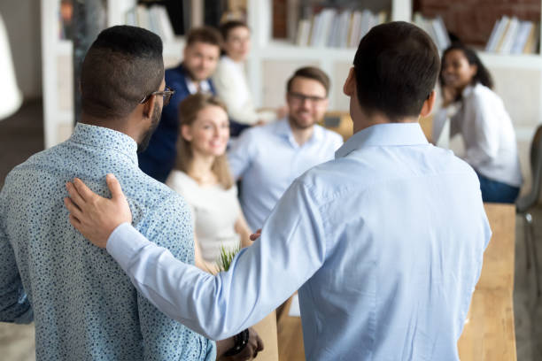 Boss introducing black new worker to workmates New mixed race employee having first working day in company standing in front of colleagues, executive manager employer introducing welcoming newcomer to workmates. Human resources employment concept employee introduction stock pictures, royalty-free photos & images
