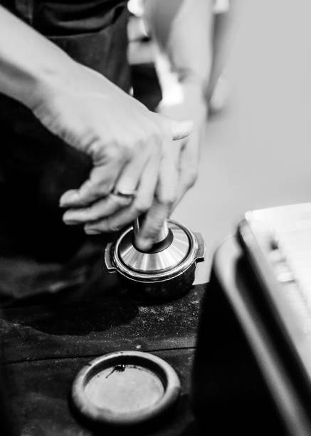Barista working in a coffee shop, Close up of barista presses ground coffee using tamper, Barista Make Coffee Portafilter Concept