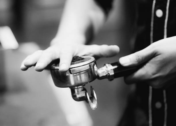 Barista working in a coffee shop, Close up of barista presses ground coffee using tamper, Barista Make Coffee Portafilter Concept