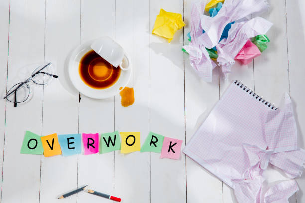 istock OVERWORK. Message in wooden cubes on a desk background. 1138951253