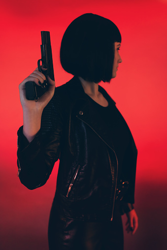 Mujer Con Arma Vestida De Negro Contra Fondo Rojo Foto de stock y más banco  de imágenes de Película de suspense - Película de suspense, Sensualidad, A  la moda - iStock