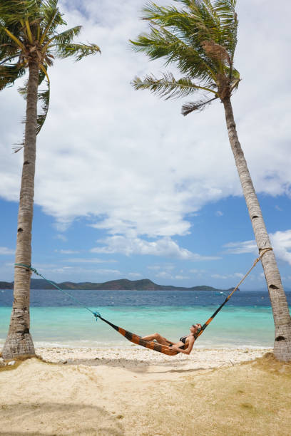 istock Woman relaxing at the beach on a hammock 1138966566