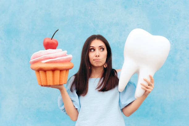 Funny Woman Holding Big Cupcake and Tooth Girl having dental problems after eating too much sugar dental cavity photos stock pictures, royalty-free photos & images