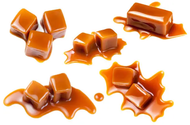 Photo of Set of Flowing caramel candies and sauce isolated on white background. Golden Butterscotch toffee caramel liquid 