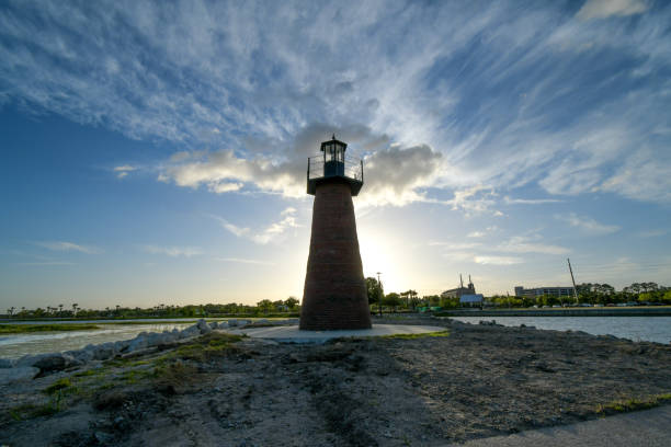 istock A silhouette of an old lighthouse against the setting sun surrounded by water on both sides gets ready for the coming night ahead. 1138975481