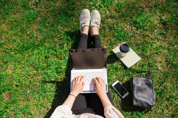 istock Woman working on laptop in park 1138976584