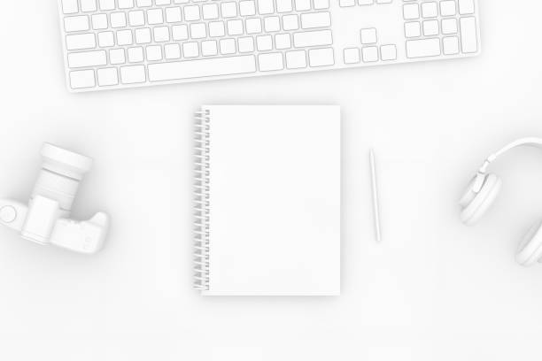Top view of notebook with pencil and keyboard on white background