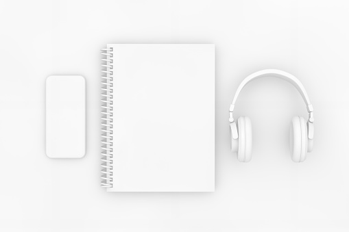 3d rendering of white color notebook with headphones and smartphone on white background. Office desktop, Workplace, Home Office.