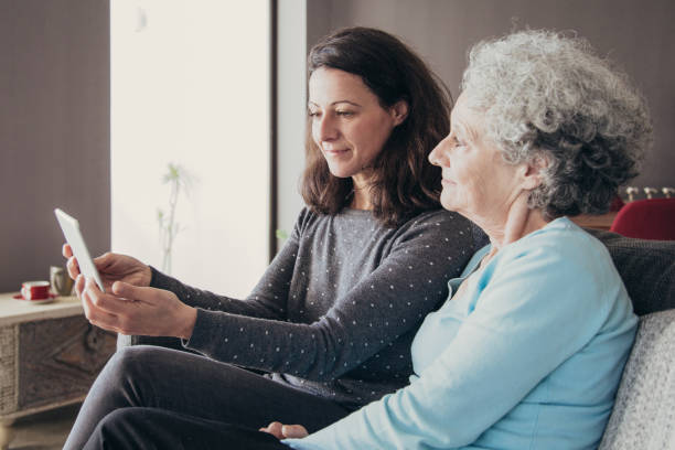 istock Content senior woman and her daughter using tablet computer 1138981911