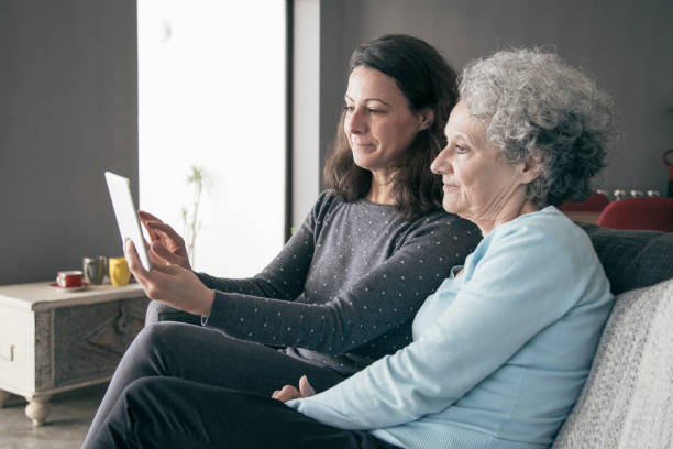 istock Focused senior woman and her daughter using tablet computer 1138981919