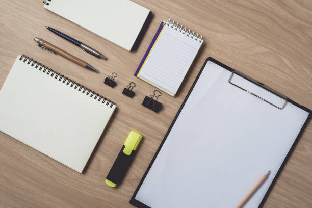 istock Workspace with diary or notebook and pen, pencil, hightlight pen, metal clip on wooden background 1138985264