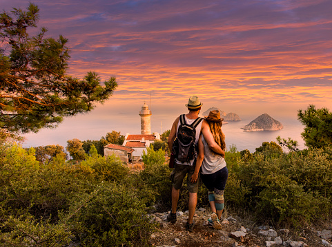 Young couple at Cape Gelidonya Lighthouse at Antalya, Turkey during sunset