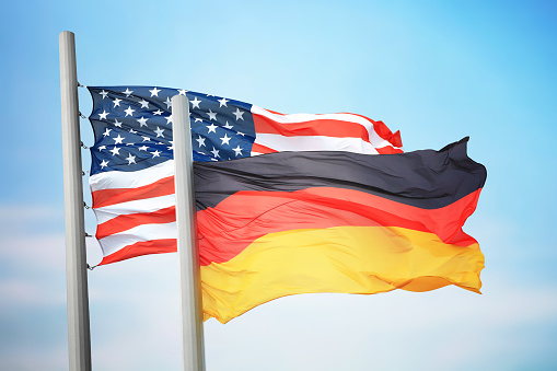 Flags of Germany and the USA against the background of the blue sky