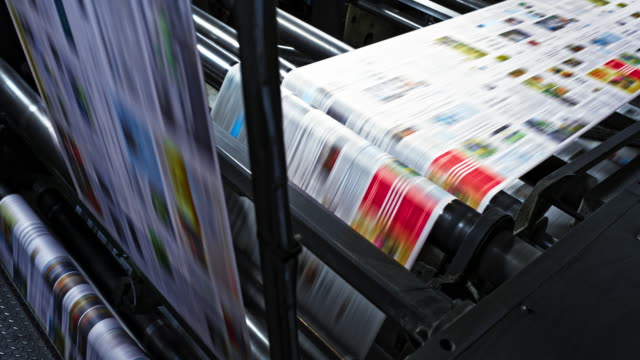 LD Printed paper travelling across the rollers of the printing press