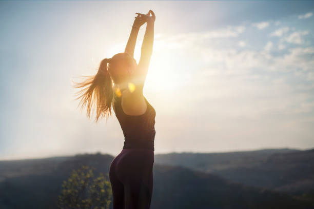 Freedom in nature, doing gymnastics on sunset light, preparation for jogging, stretching on sunset