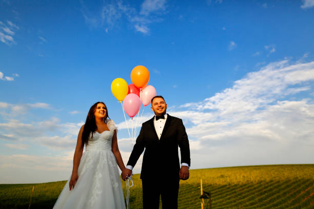 istock Happy wedding couple posing outdoor with balloons 1138992575