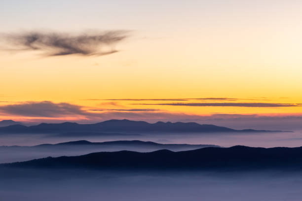 istock Beautifully colored sky at dusk, with mountains layers and mist between them 1138992751