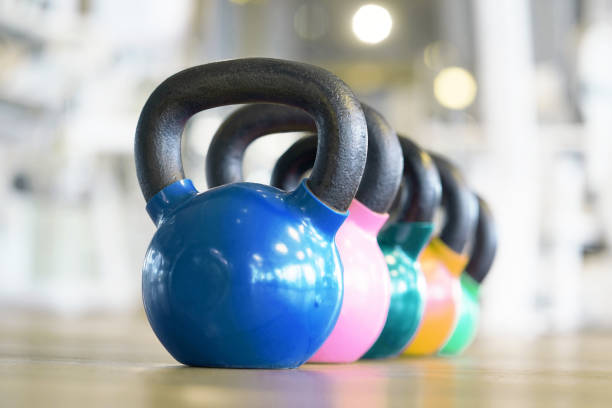 Colorful kettlebells in gym Colorful kettlebells in a row in a gym kettlebell stock pictures, royalty-free photos & images