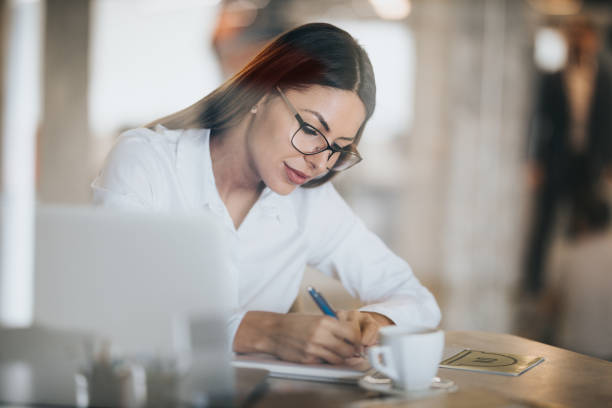 istock Beautiful businesswoman taking notes in the office. 1139004633