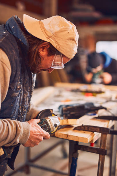 istock Male carpenter working on old wood in a retro vintage workshop. 1139005541