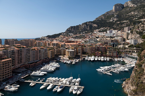Fontvieille, Monaco - March 28 2019: Boats moored in the Port de Fontvieille with the hills behind.